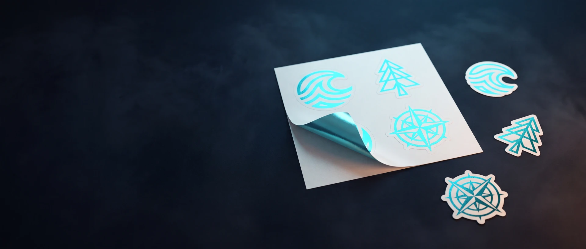 A sheet of die-cut vinyl stickers with a cyan tree mark, peeled back at one corner.
